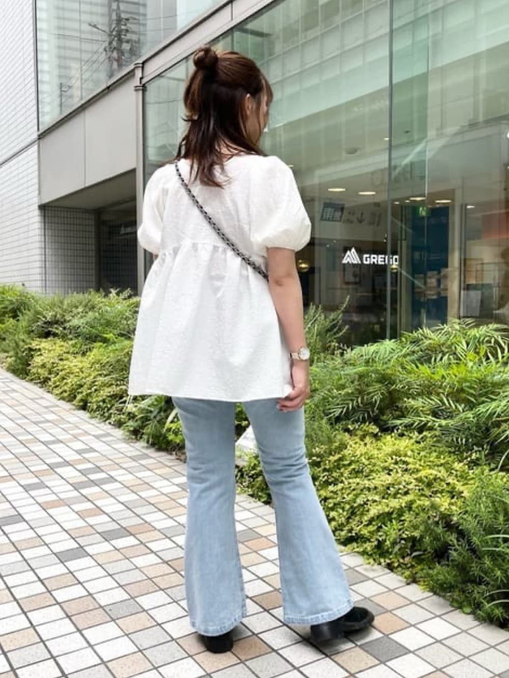 ホワイト系のシャツ/ブラウス、ブルー系のデニムパンツ、ブラック系のショルダーバッグを着用したレディースの夏コーディネートの2枚目の写真