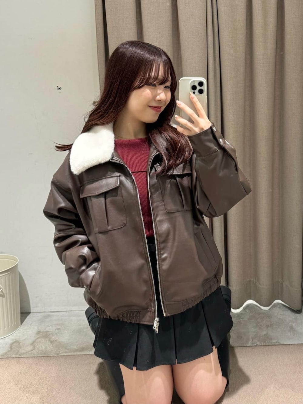 ブラウン系のブルゾン、ブラック系のスカート、ブラック系のブーツを着用したレディースの冬コーディネートの3枚目の写真