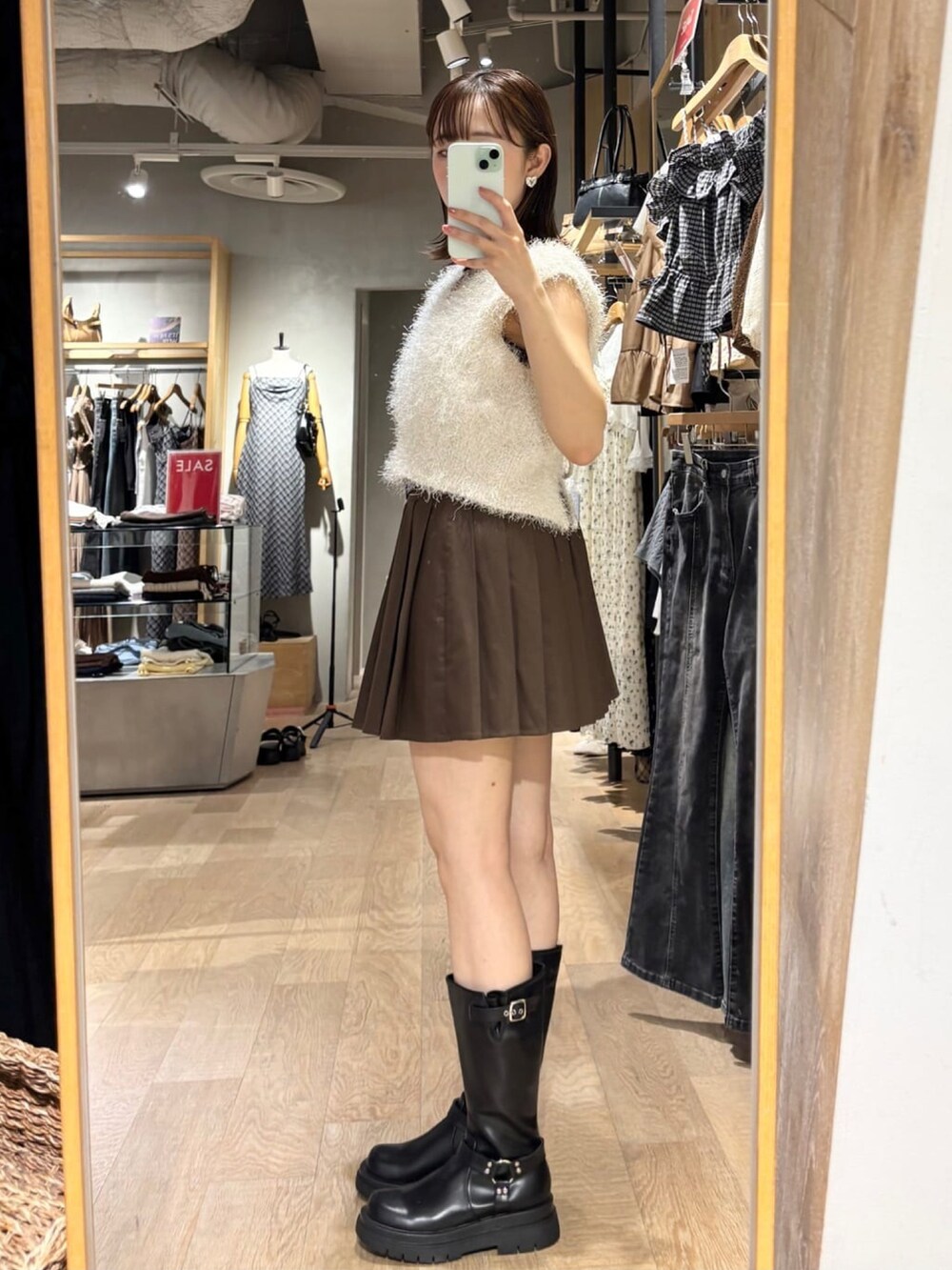ブラウン系のスカート、ホワイト系のベストを着用したレディースの夏コーディネートの2枚目の写真