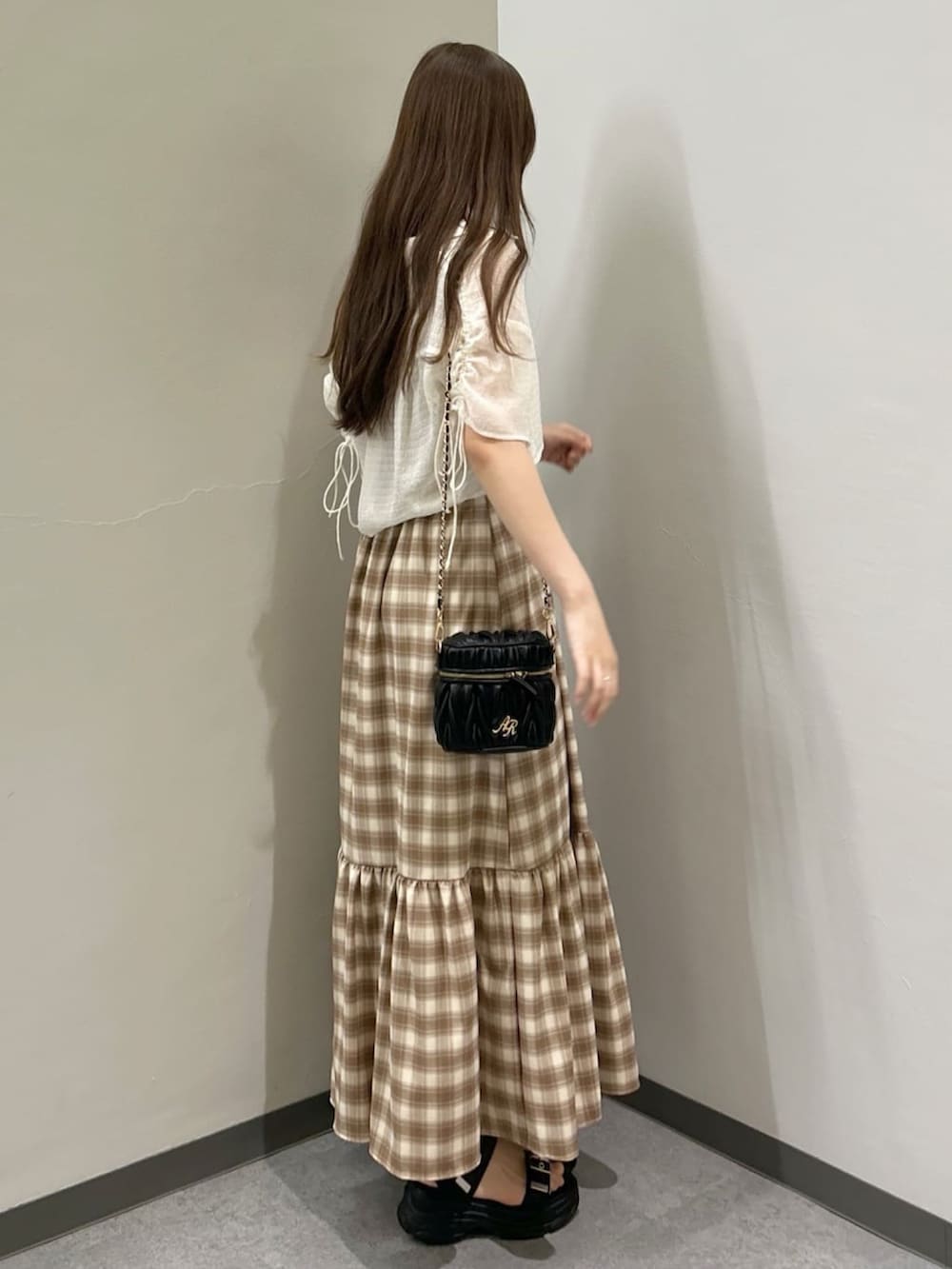 ホワイト系のシャツ/ブラウス、ブラウン系のワンピース、ブラック系のサンダルを着用したレディースの夏コーディネートの2枚目の写真