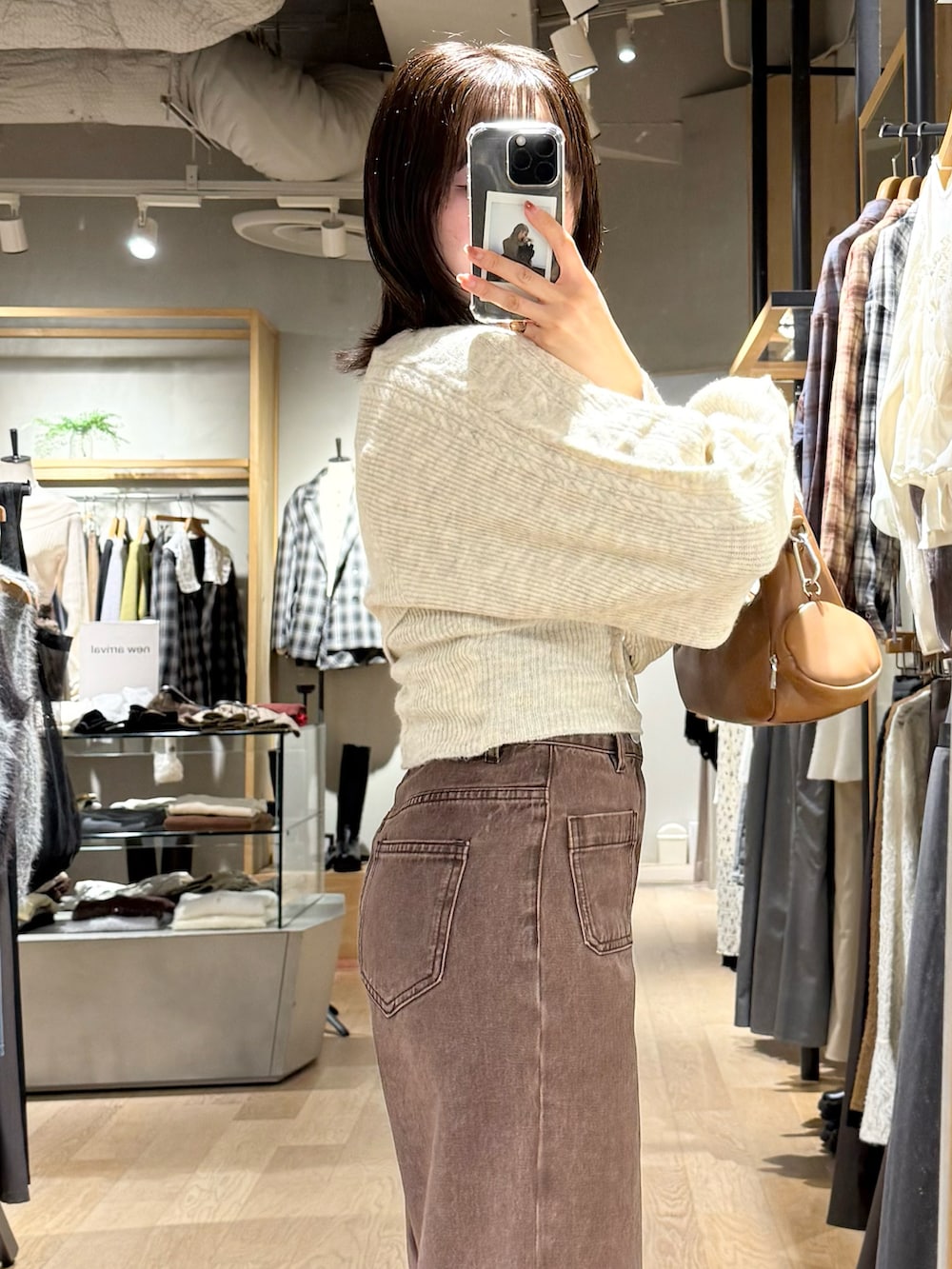 ホワイト系のアンサンブル、ブラウン系のデニムパンツを着用したレディースの秋コーディネートの3枚目の写真