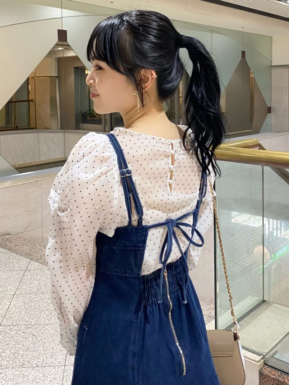 ホワイト系のシャツ/ブラウス、ブルー系のワンピース、ブラック系のショルダーバッグを着用したレディースの春コーディネートの2枚目の写真