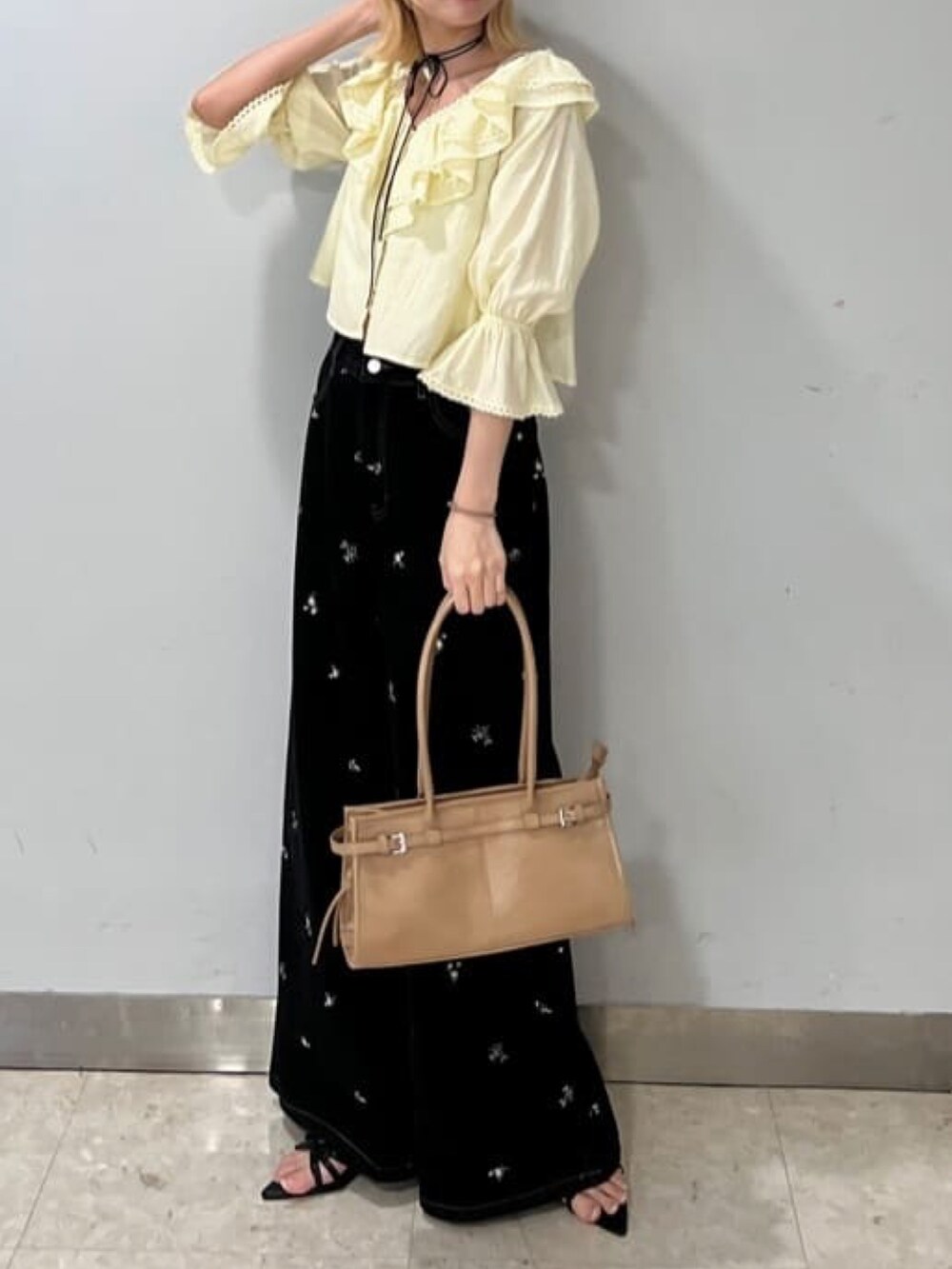 イエロー系のシャツ/ブラウス、ブラック系のデニムパンツを着用したレディースの春コーディネートの2枚目の写真