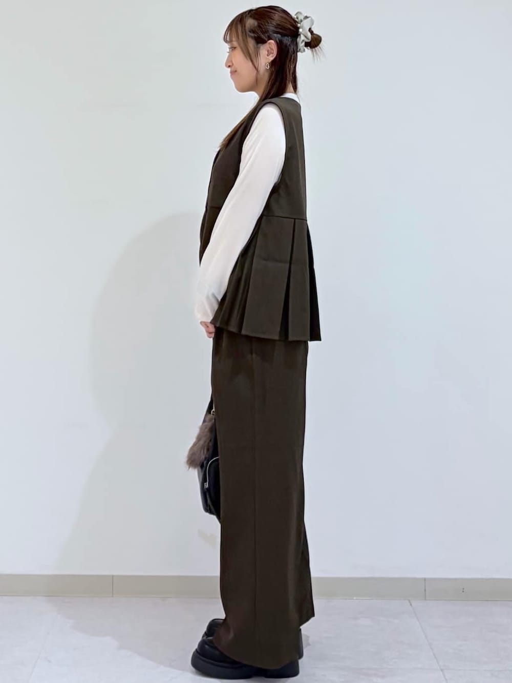 ブラウン系のその他パンツ、ブラック系のパンプス、ブラウン系のシャツ/ブラウスを着用したレディースの秋コーディネートの2枚目の写真