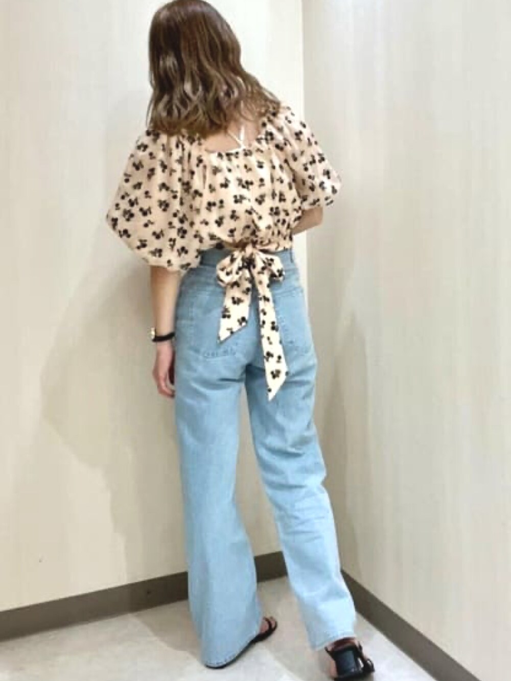 オレンジ系のシャツ/ブラウス、ブルー系のデニムパンツを着用したレディースの春コーディネートの2枚目の写真