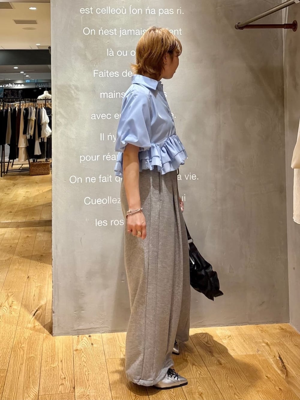 グレー系のスウェットパンツ、ブルー系のシャツ/ブラウス、グレー系のパンプスを着用したレディースの夏コーディネートの2枚目の写真