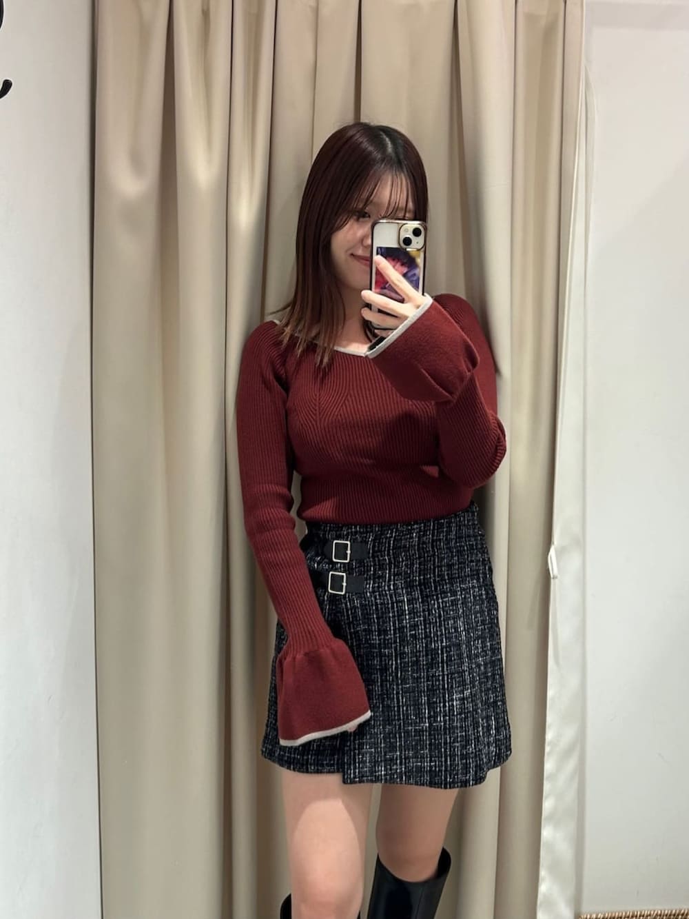 レッド系のニット/セーター、グレー系のスカート、ホワイト系のショルダーバッグを着用したレディースの冬コーディネートの2枚目の写真