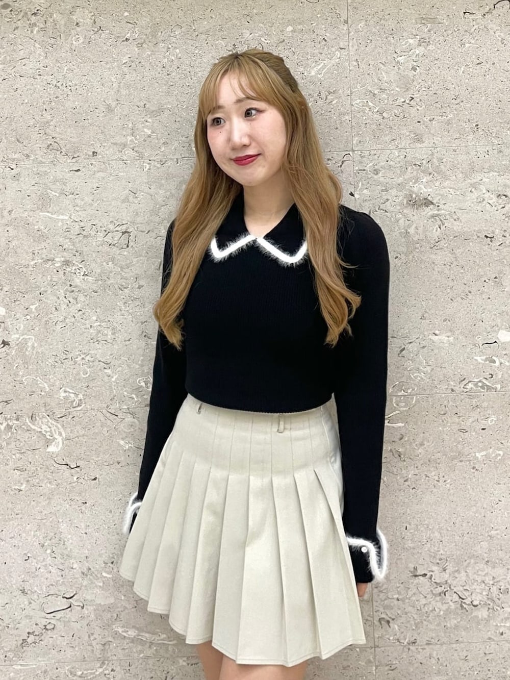 ブラック系のニット/セーター、ホワイト系のスカート、ブラック系のボストンバッグを着用したレディースの冬コーディネートの3枚目の写真