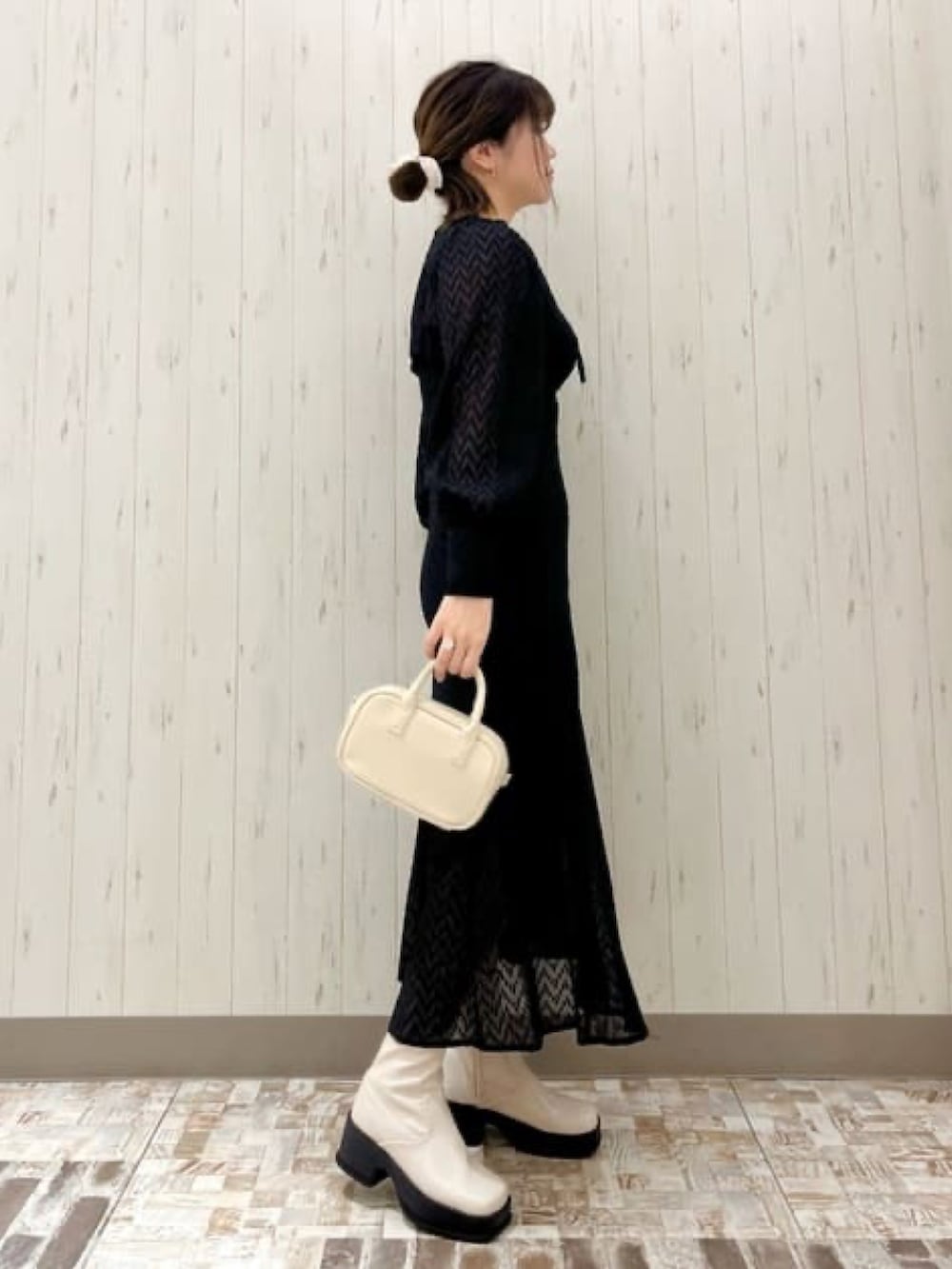 ブラック系のワンピース、ホワイト系のボストンバッグを着用したレディースの冬コーディネートの2枚目の写真