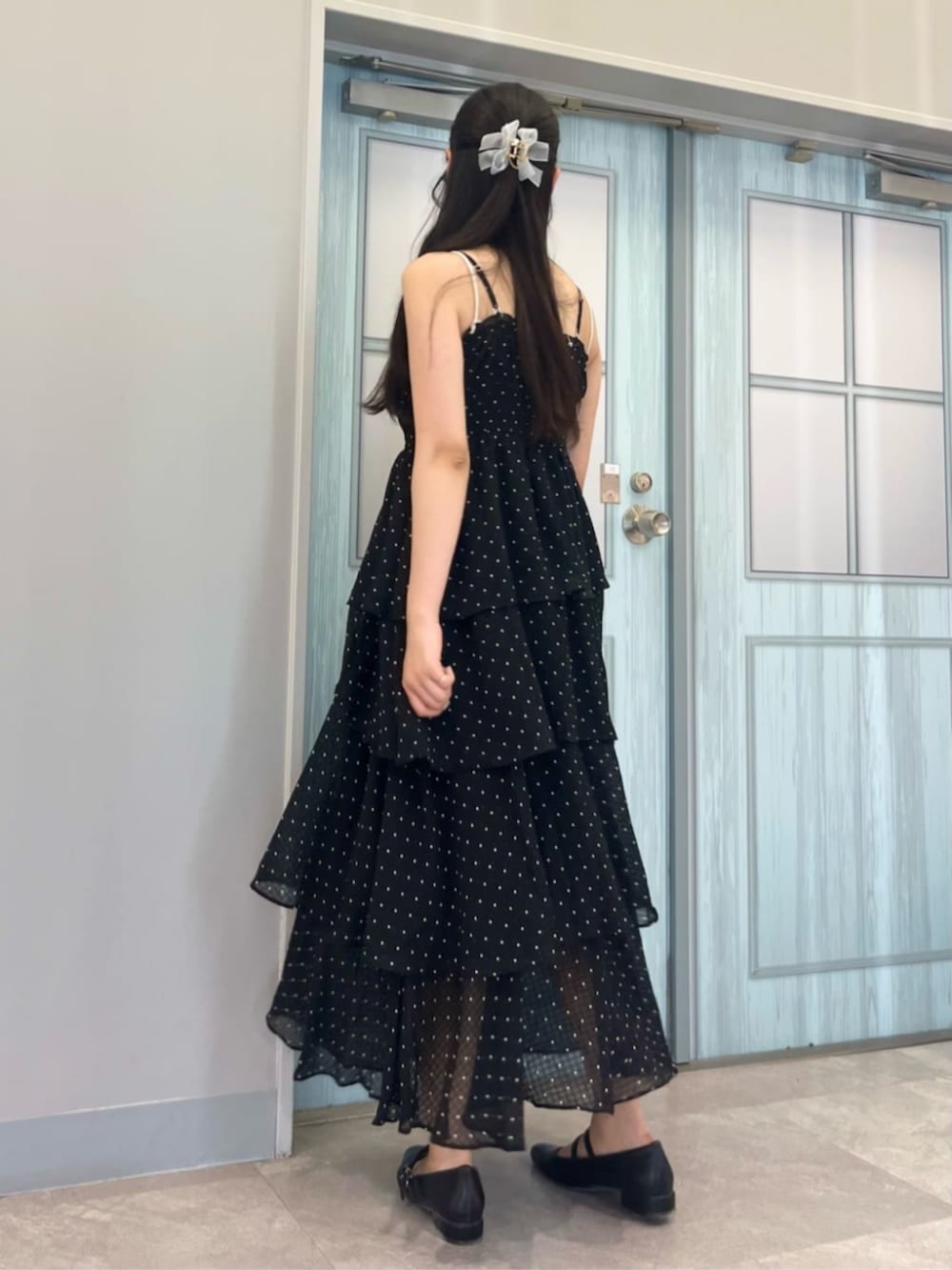 ブラック系のパンプス、ホワイト系のショルダーバッグ、ブラック系のワンピースを着用したレディースの夏コーディネートの5枚目の写真