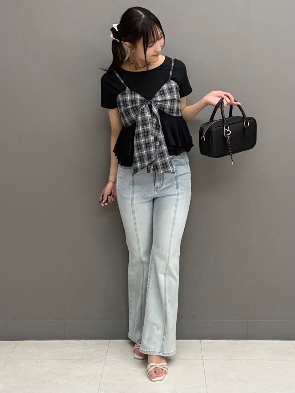ブラック系のTシャツ/カットソー、ブルー系のデニムパンツを着用したレディースの夏コーディネートの2枚目の写真