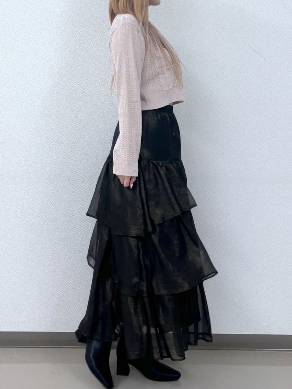 ピンク系のカーディガン/ボレロ、ブラック系のスカートを着用したレディースの冬コーディネートの2枚目の写真