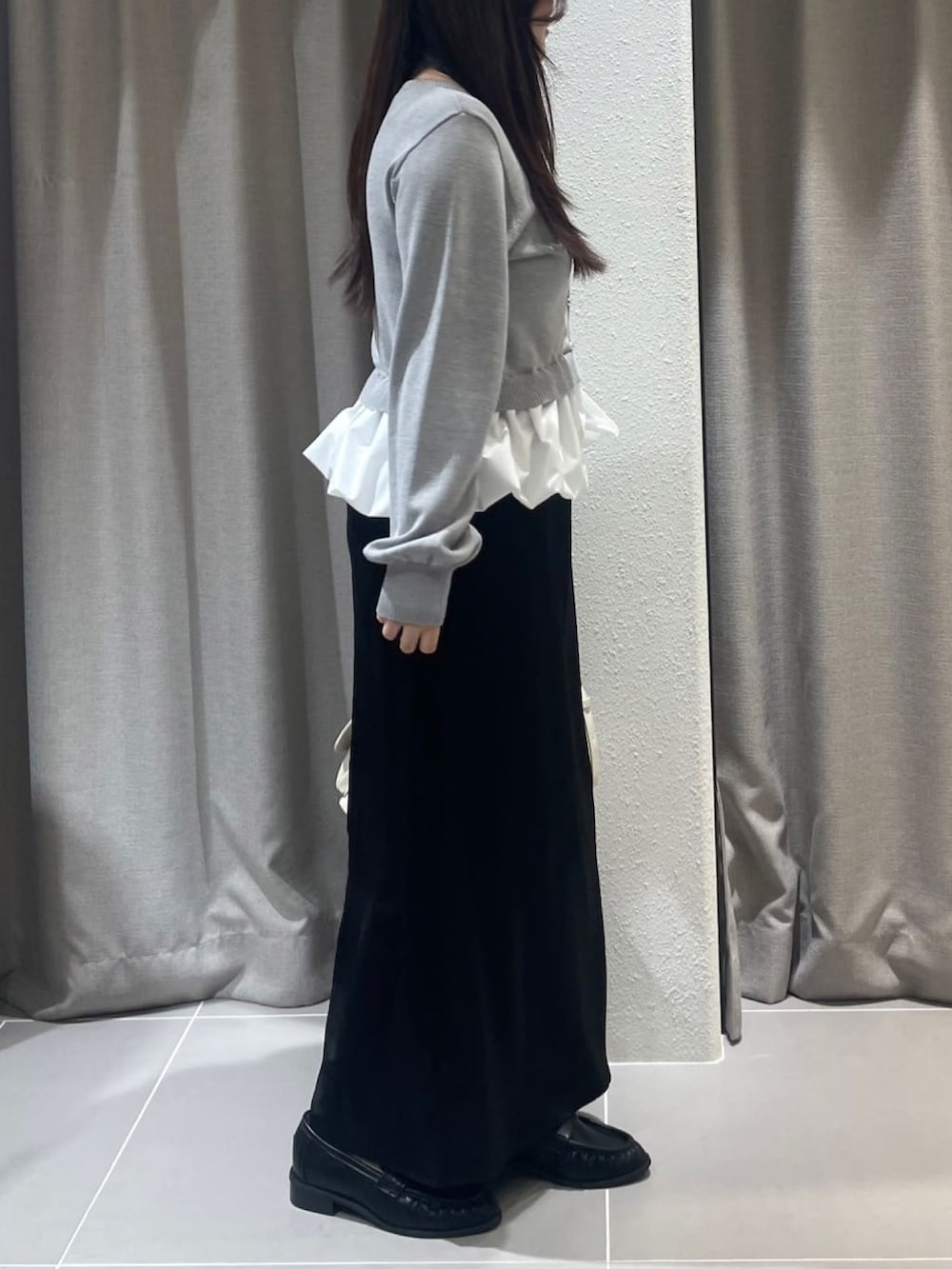 グレー系のニット/セーター、ブラック系のスカートを着用したレディースの冬コーディネートの2枚目の写真