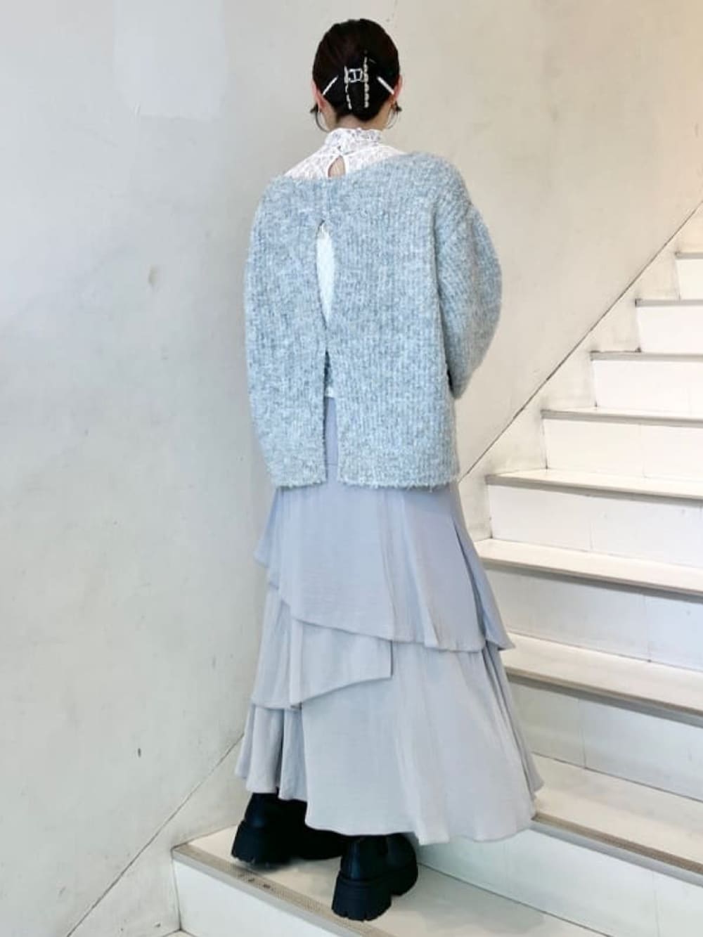 ブルー系のニット/セーター、ホワイト系のTシャツ/カットソー、グレー系のスカートを着用したレディースの冬コーディネートの3枚目の写真