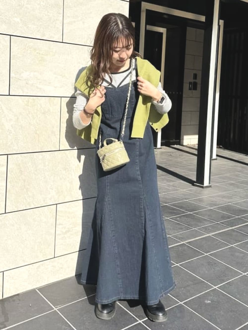 グリーン系のカーディガン/ボレロ、ブルー系のワンピース、グリーン系のショルダーバッグを着用したレディースの冬コーディネートの2枚目の写真