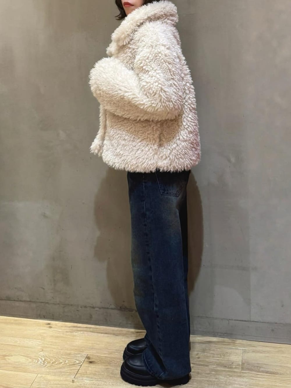 ホワイト系のブルゾン、ブルー系のデニムパンツ、ブラック系のローファーを着用したレディースの秋コーディネートの2枚目の写真