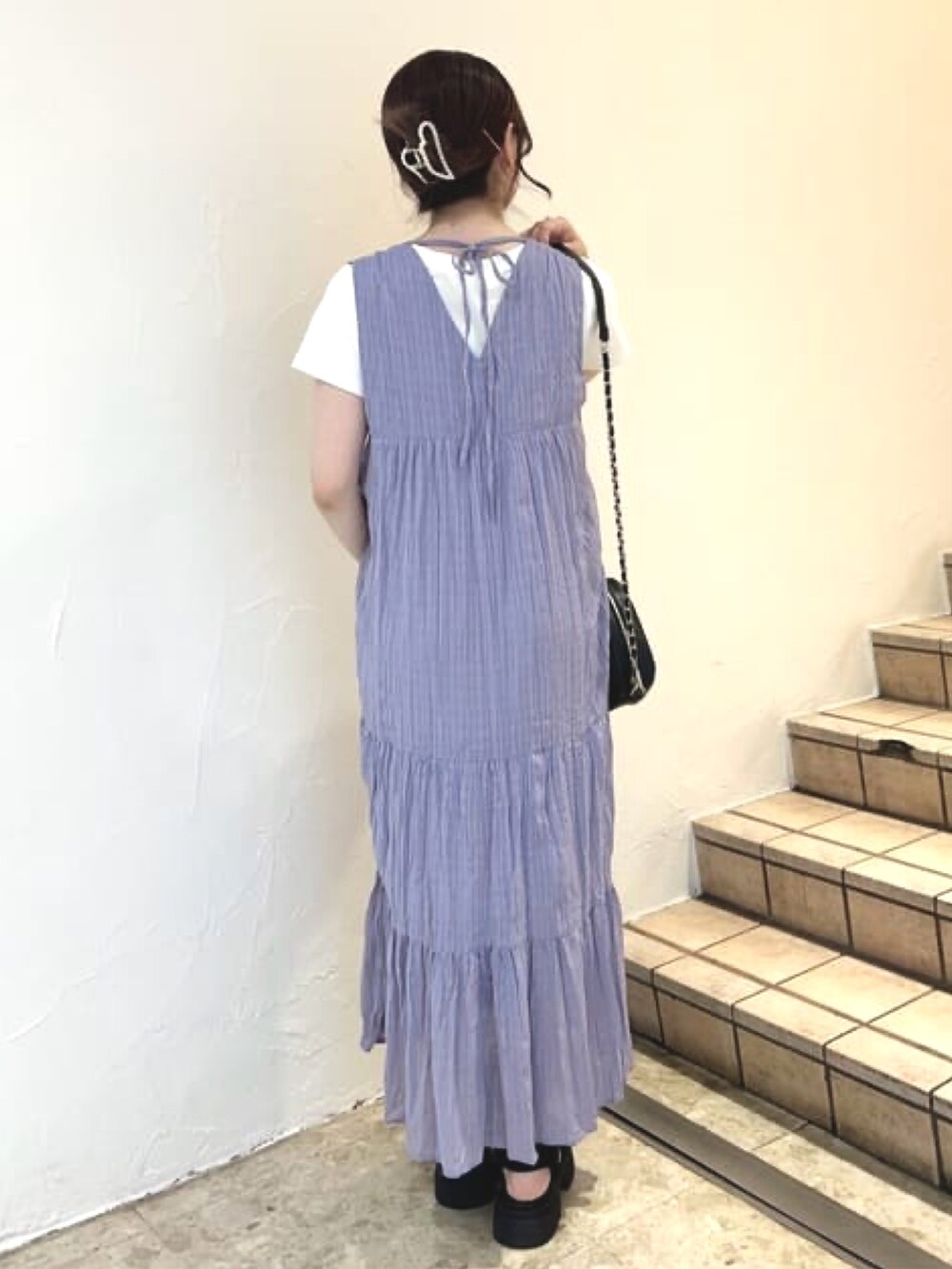 パープル系のワンピース、ホワイト系のTシャツ/カットソー、ブラック系のサンダルを着用したレディースの夏コーディネートの3枚目の写真