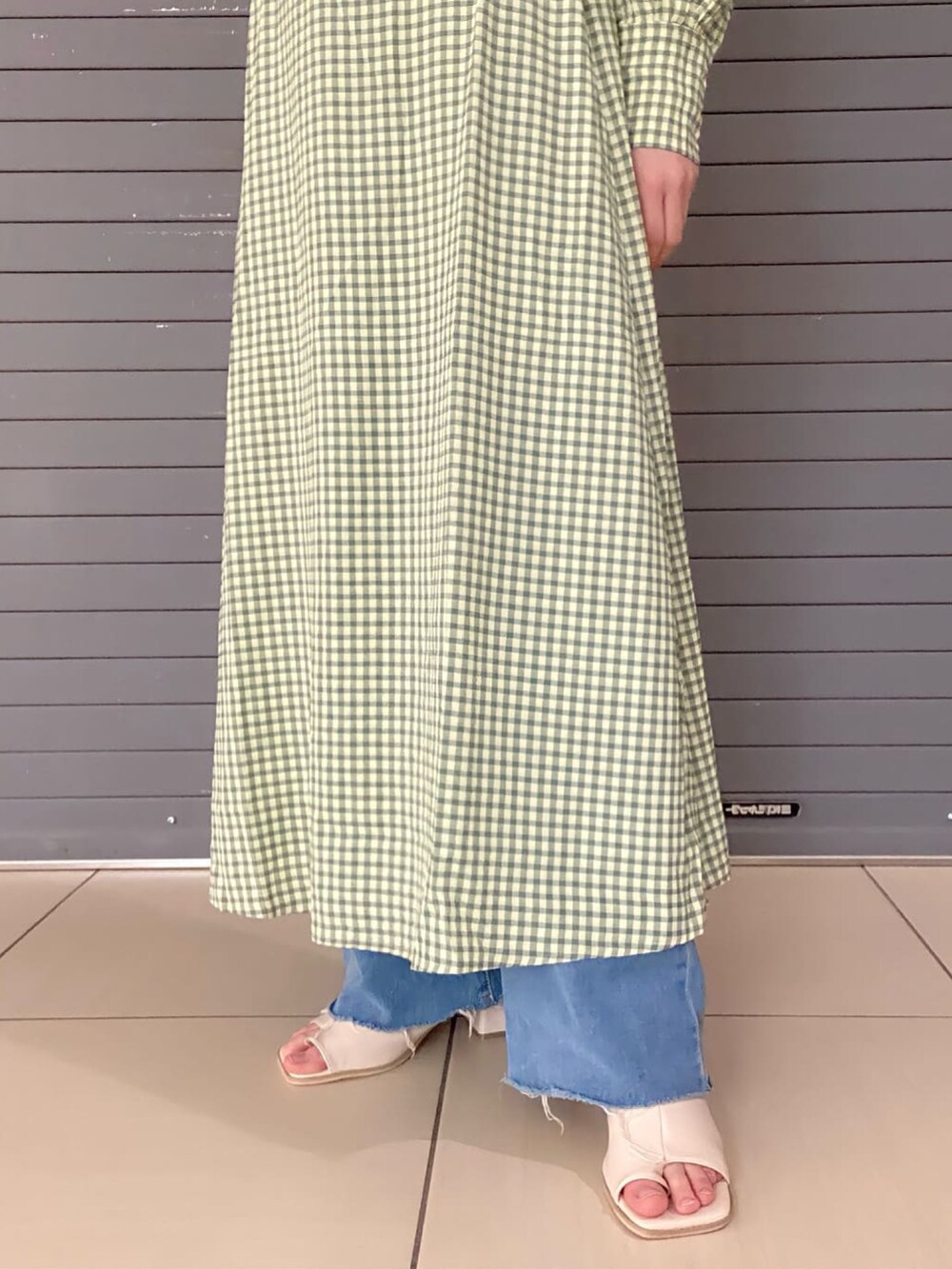 グリーン系のワンピース、ホワイト系のブーツを着用したレディースの春コーディネートの4枚目の写真