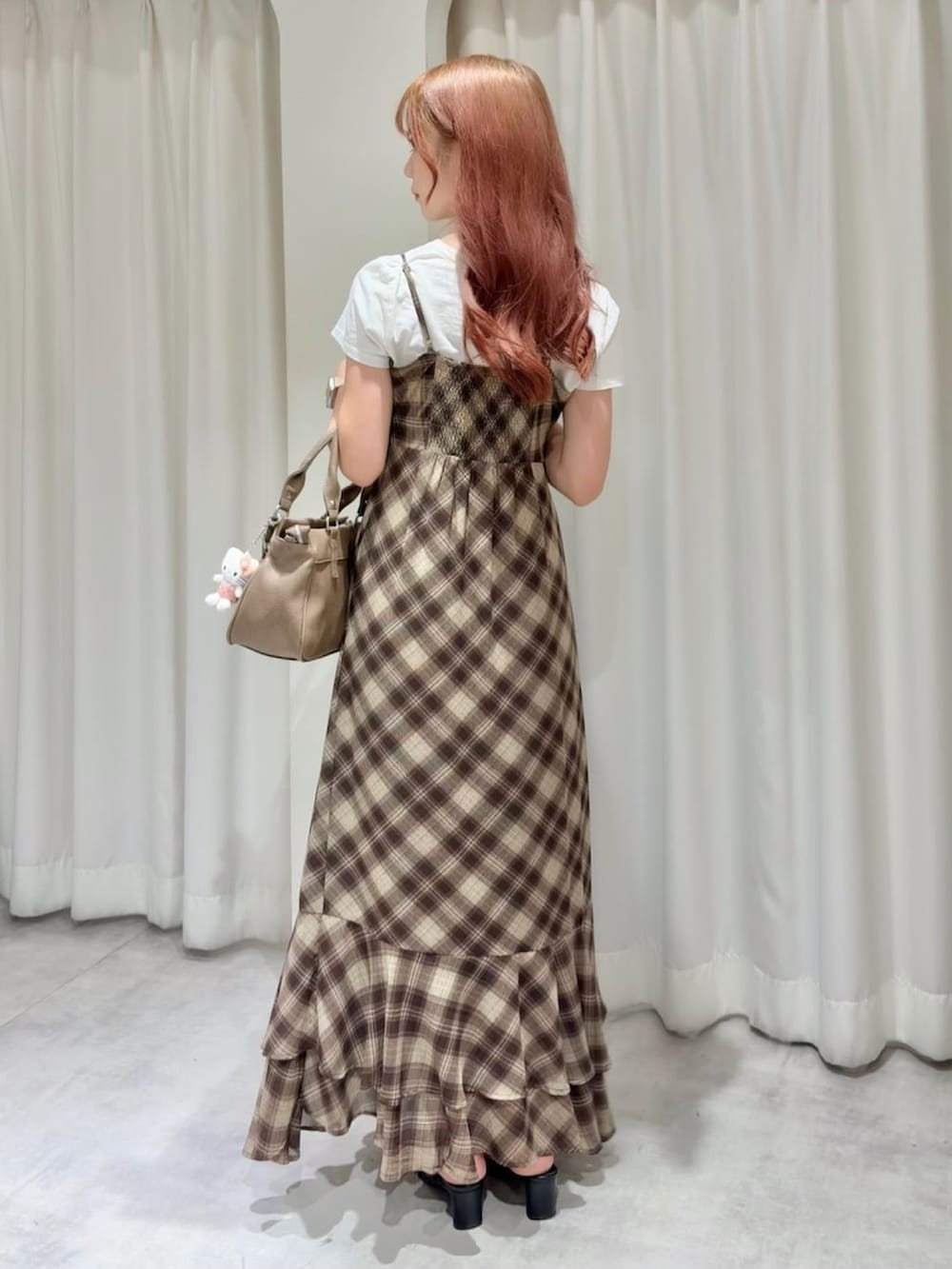ブラウン系のワンピース、ブラウン系のショルダーバッグ、ホワイト系のTシャツ/カットソーを着用したレディースの夏コーディネートの2枚目の写真