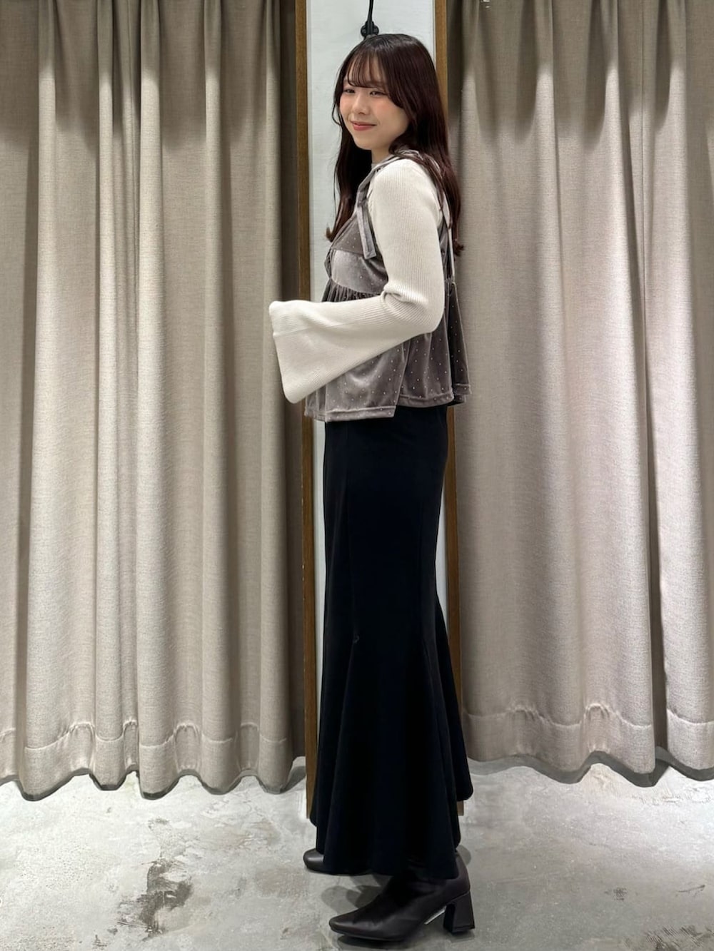 ピンク系のアンサンブル、ブラック系のスカートを着用したレディースの冬コーディネートの2枚目の写真