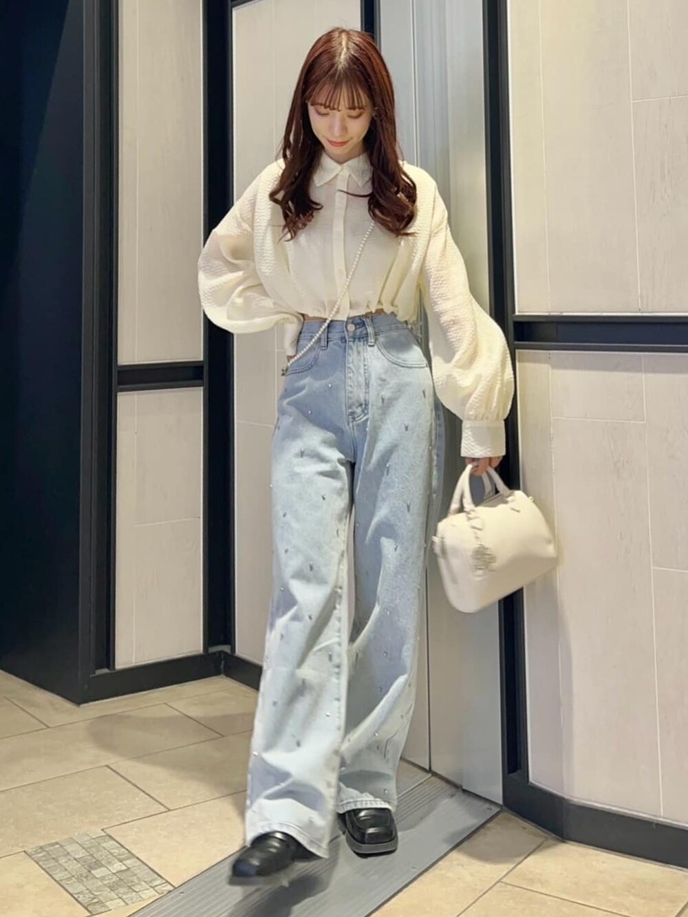 ホワイト系のシャツ/ブラウス、ブルー系のデニムパンツを着用したレディースの春コーディネートの2枚目の写真