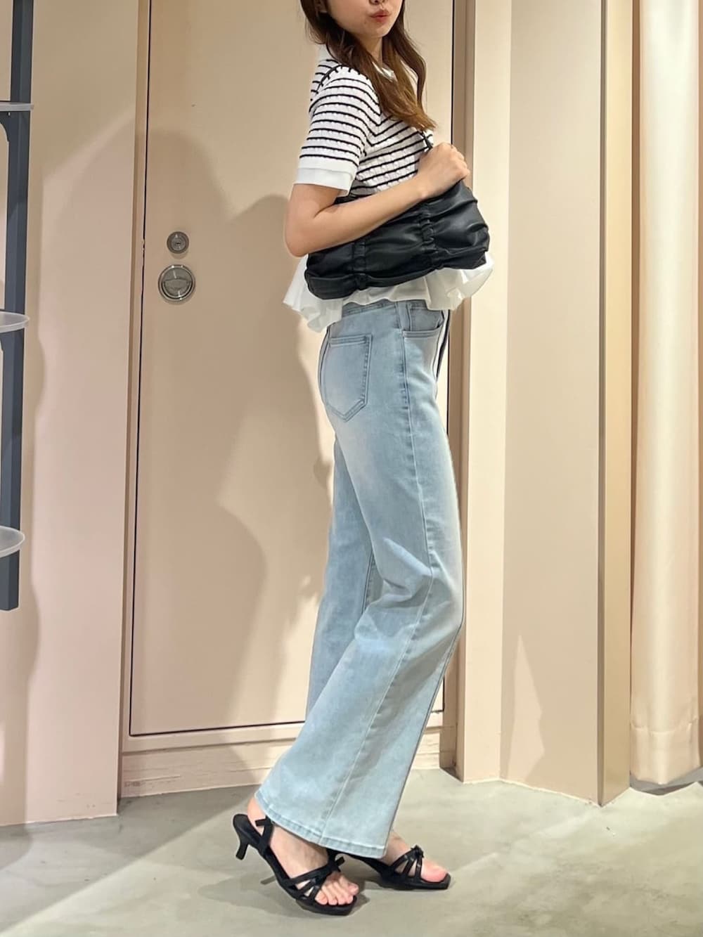ホワイト系のニット/セーター、ブルー系のデニムパンツを着用したレディースの春コーディネートの2枚目の写真