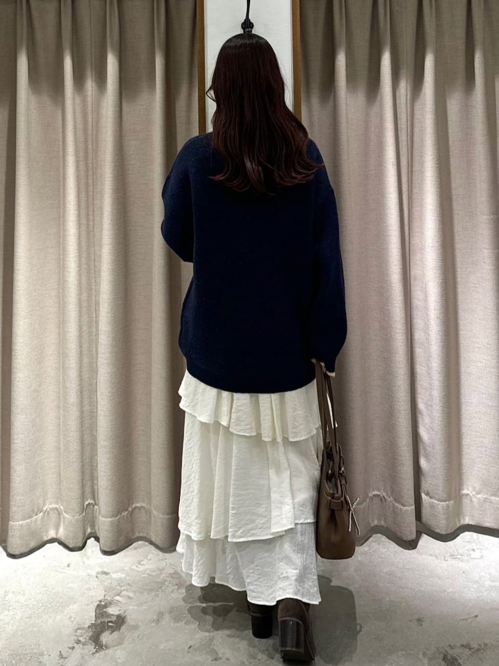 ブルー系のニット/セーター、ホワイト系のスカートを着用したレディースの秋コーディネートの3枚目の写真