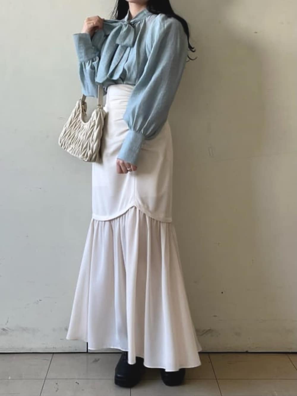 ブルー系のシャツ/ブラウス、ホワイト系のスカート、ホワイト系のハンドバッグを着用したレディースの冬コーディネートの2枚目の写真