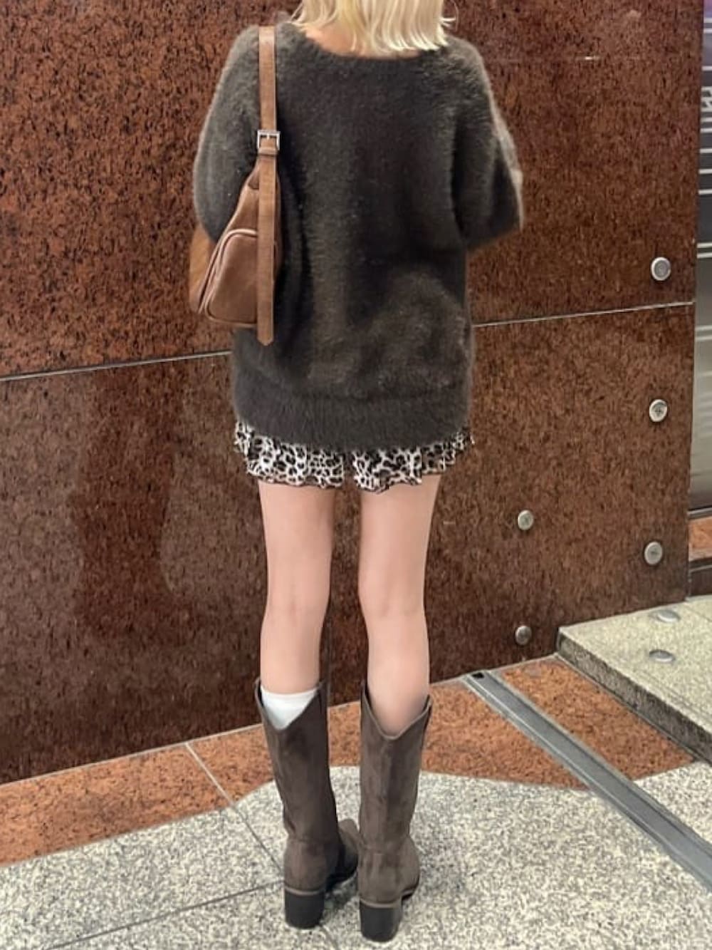 ブラウン系のニット/セーター、ブラウン系のスカート、ブラウン系のブーツを着用したレディースの秋コーディネートの3枚目の写真