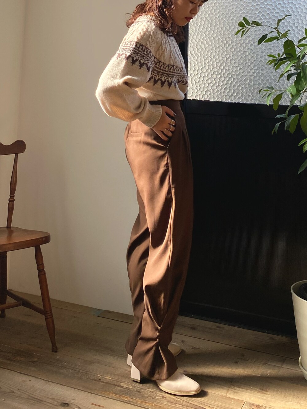 ブラック系のボストンバッグ、ホワイト系のニット/セーター、ブラウン系のその他パンツを着用したレディースの冬コーディネートの3枚目の写真