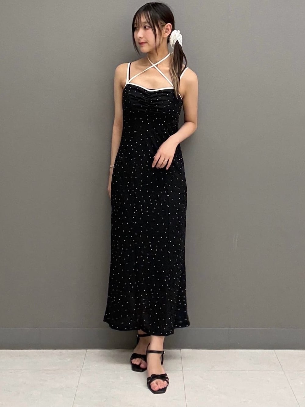 ブラック系のワンピース、ブラック系のサンダル、ホワイト系のニット/セーターを着用したレディースの夏コーディネートの4枚目の写真