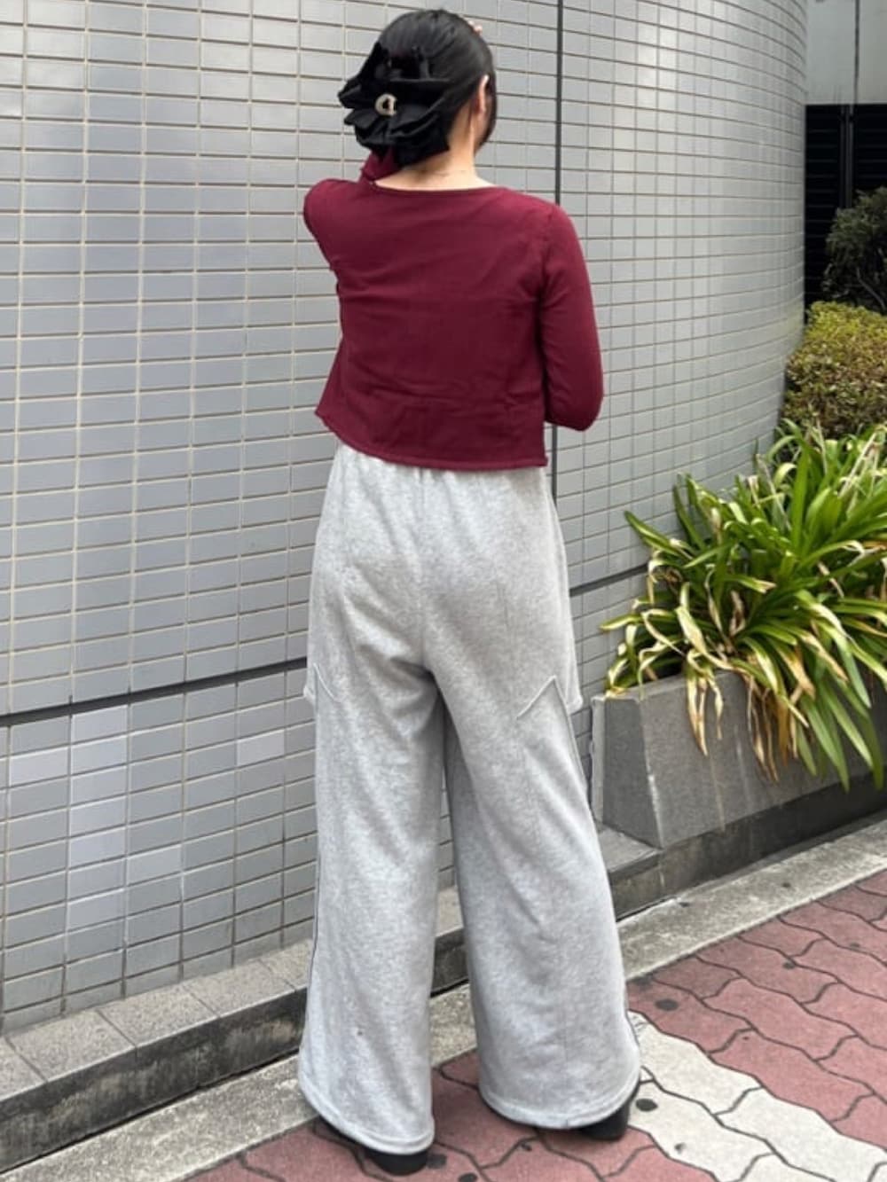 レッド系のアンサンブル、ベージュ系のその他パンツを着用したレディースの夏コーディネートの3枚目の写真