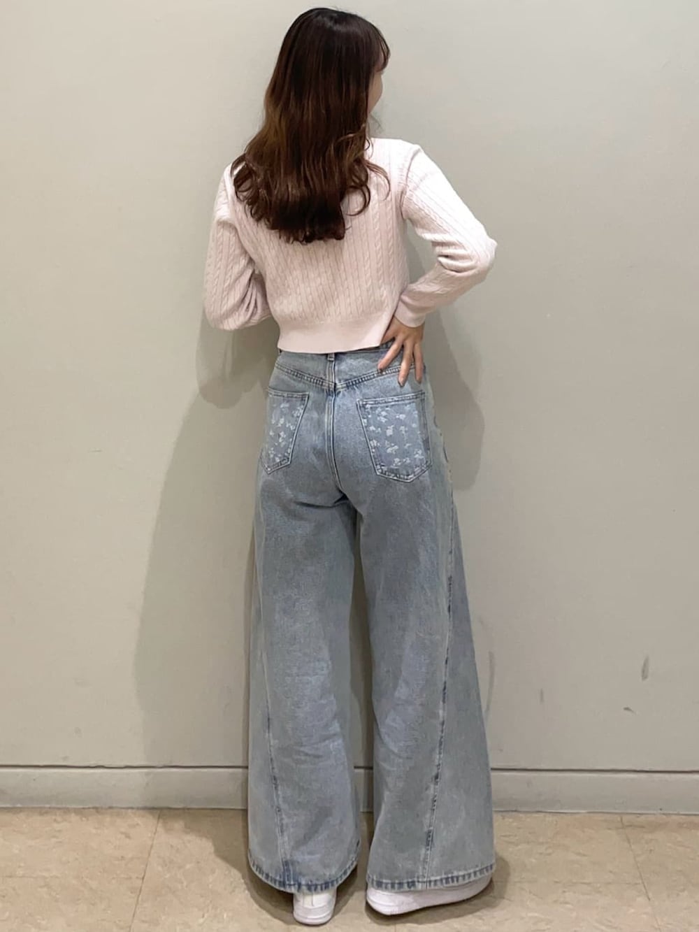 ピンク系のニット/セーター、ブルー系のデニムパンツを着用したレディースの冬コーディネートの2枚目の写真