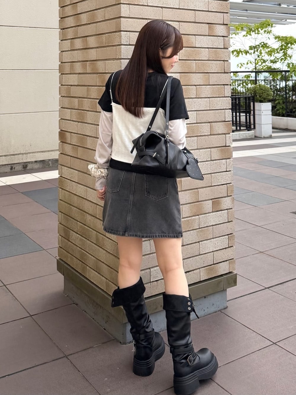 ホワイト系のTシャツ/カットソー、ブラック系のデニムスカート、ブラック系のボストンバッグを着用したレディースの秋コーディネートの3枚目の写真