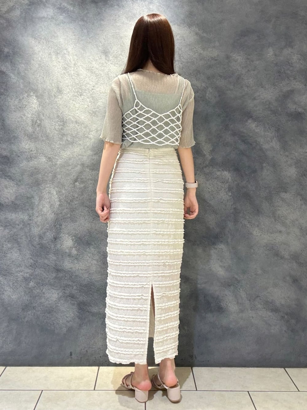 ベージュ系のベスト、グリーン系のシャツ/ブラウス、ホワイト系のスカートを着用したレディースの夏コーディネートの2枚目の写真