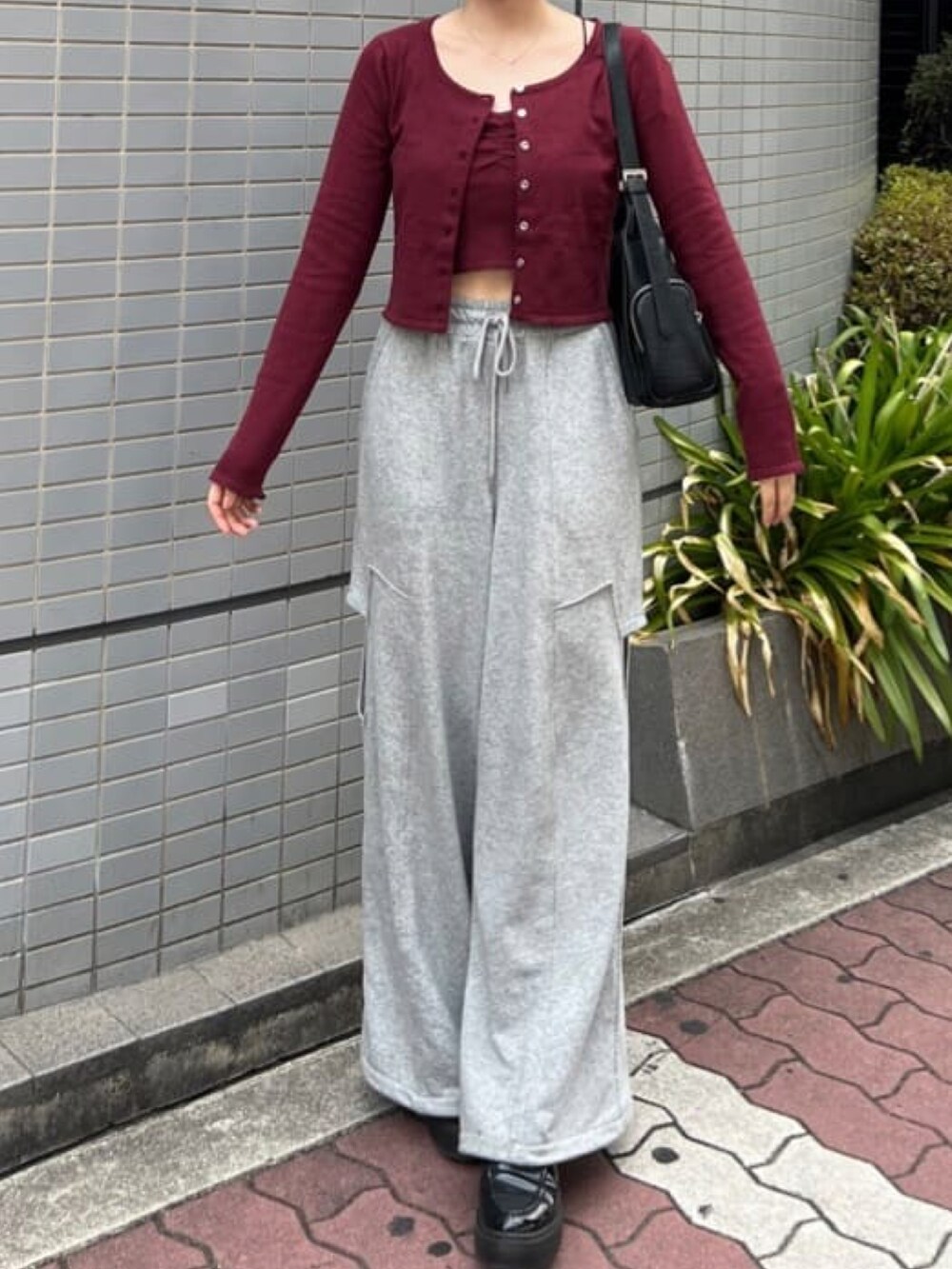 レッド系のアンサンブル、ベージュ系のその他パンツを着用したレディースの夏コーディネートの2枚目の写真