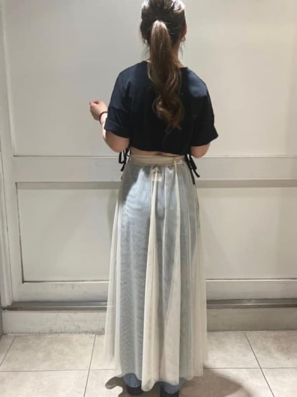 ブラック系のTシャツ/カットソー、ホワイト系のスカート、ブルー系のデニムパンツを着用したレディースの夏コーディネートの3枚目の写真