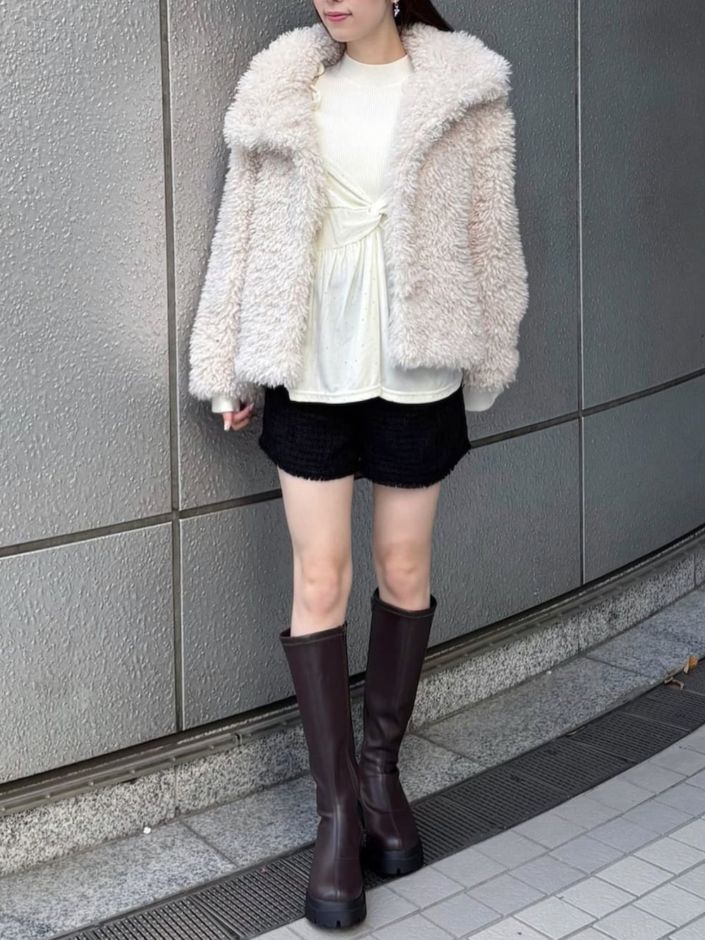 ホワイト系のブルゾンを着用したレディースの冬コーディネートの2枚目の写真