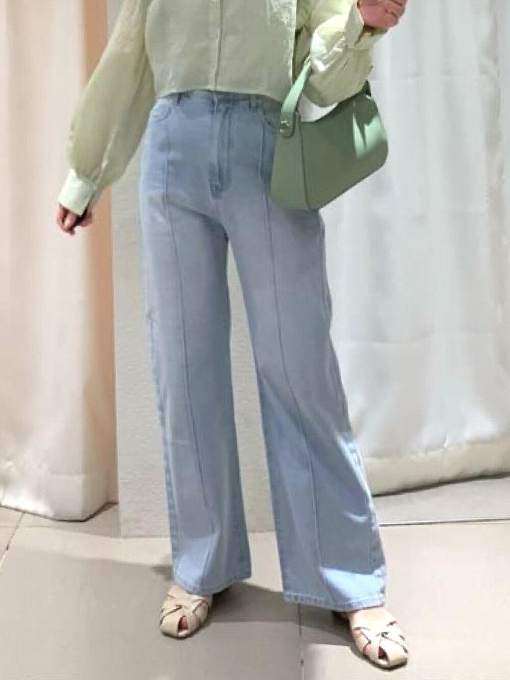 グリーン系のシャツ/ブラウス、ブルー系のデニムパンツ、グリーン系のハンドバッグを着用したレディースの春コーディネートの3枚目の写真