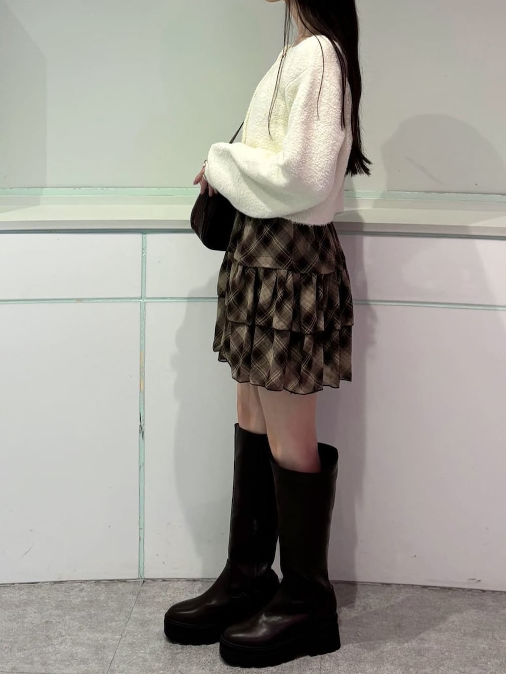 ホワイト系のカーディガン/ボレロ、ブラウン系のスカートを着用したレディースの秋コーディネートの2枚目の写真