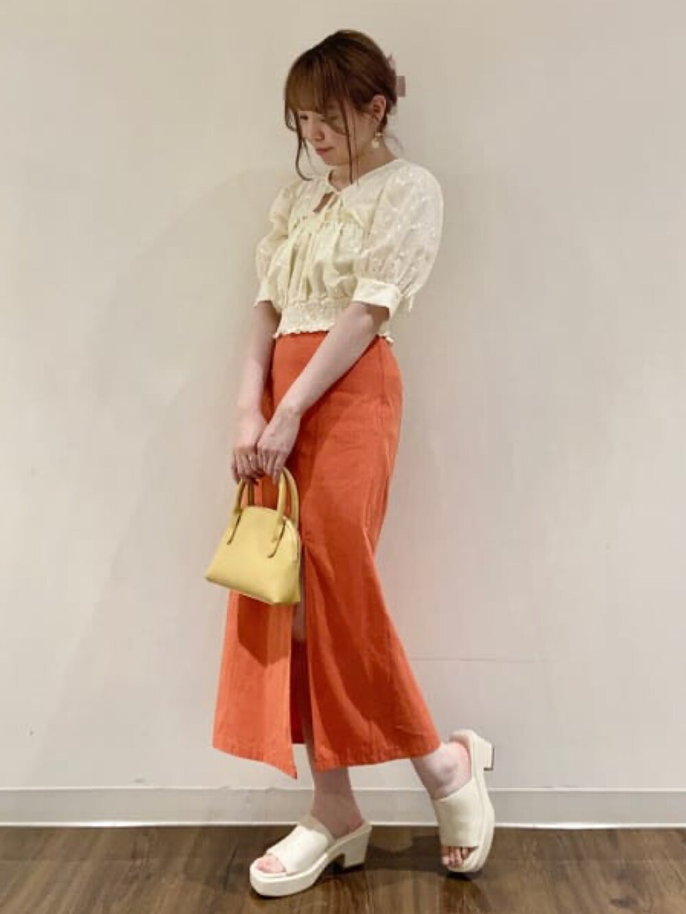 ホワイト系のシャツ/ブラウス、オレンジ系のスカート、ホワイト系のサンダルを着用したレディースの春コーディネートの2枚目の写真