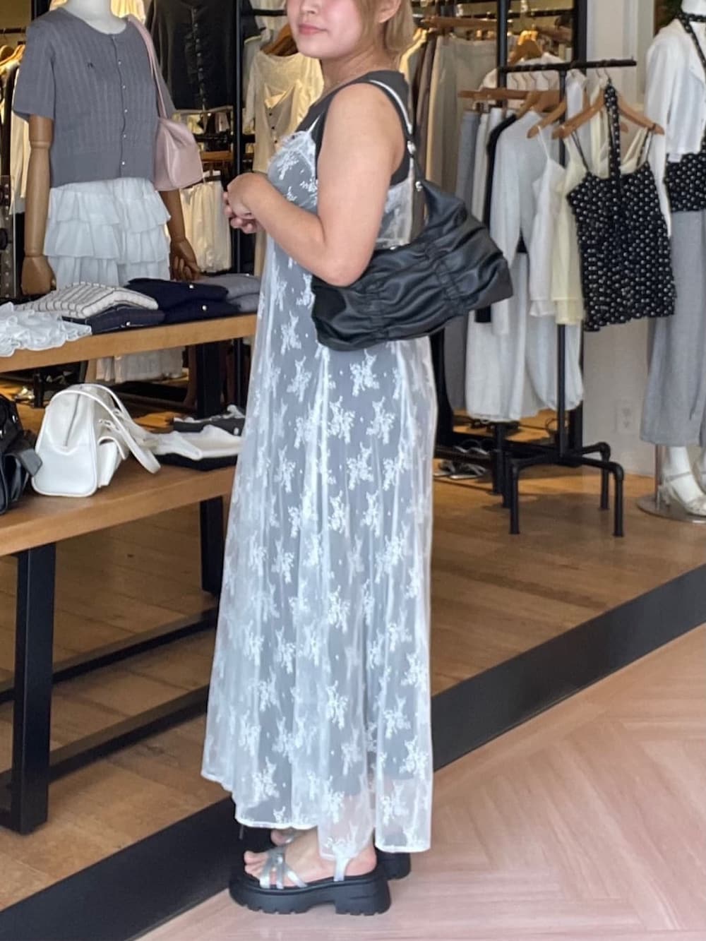 グレー系のワンピース、グレー系のサンダル、ブラック系のショルダーバッグを着用したレディースの夏コーディネートの2枚目の写真