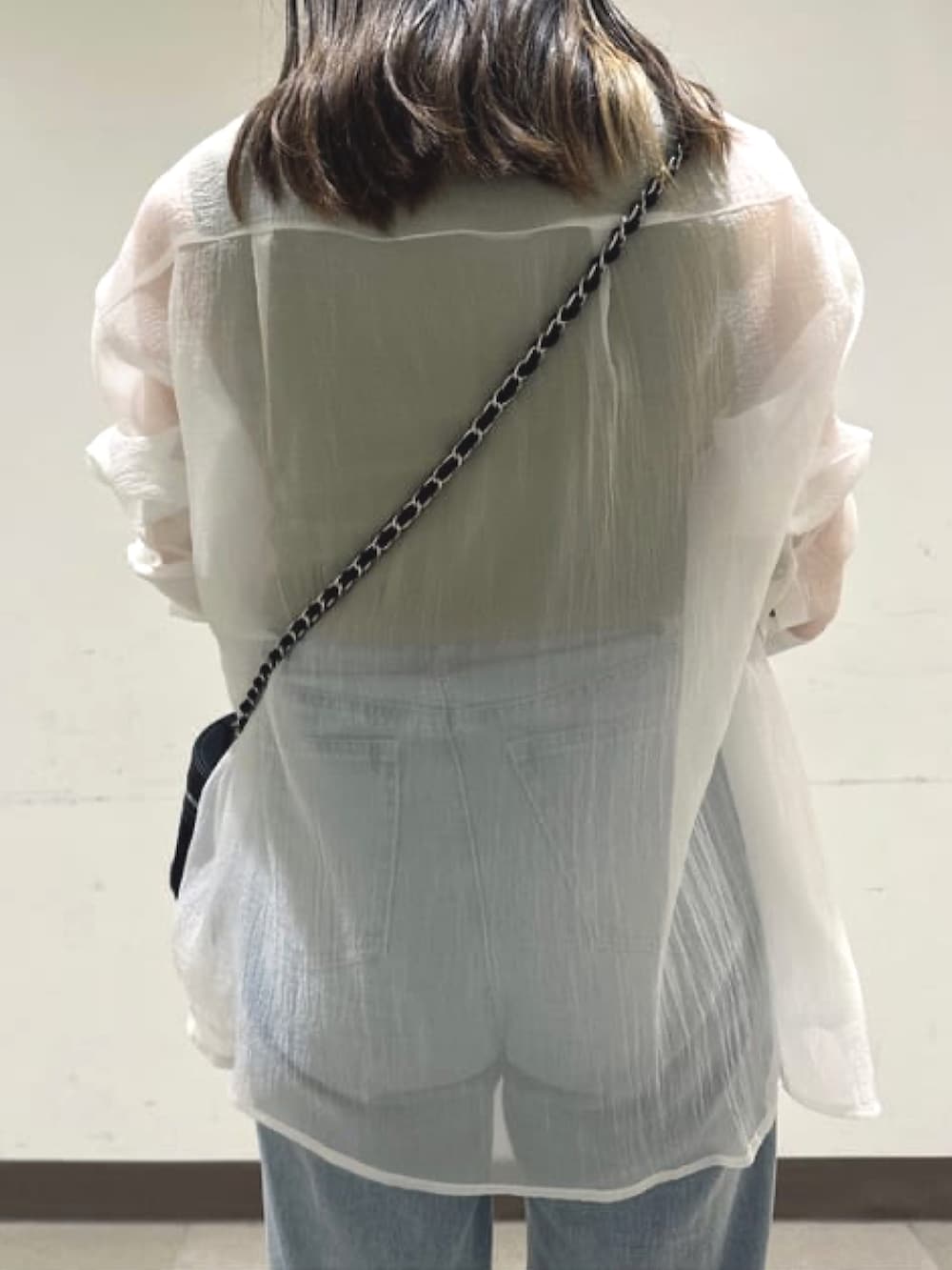 ブラック系のショルダーバッグ、ホワイト系のシャツ/ブラウス、ブルー系のデニムパンツを着用したレディースの夏コーディネートの4枚目の写真