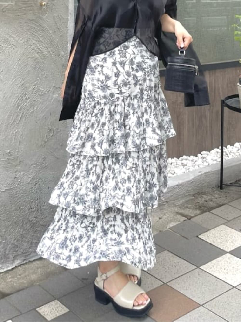 ブラック系のシャツ/ブラウス、ホワイト系のスカート、ホワイト系のサンダルを着用したレディースの夏コーディネートの5枚目の写真