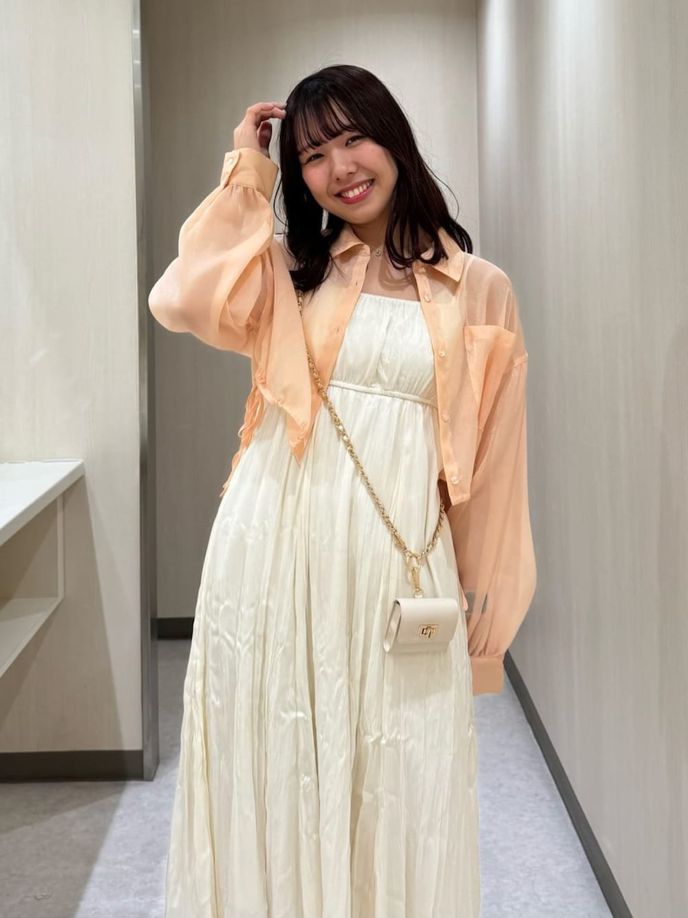 ホワイト系のワンピース、オレンジ系のシャツ/ブラウスを着用したレディースの春コーディネートの2枚目の写真