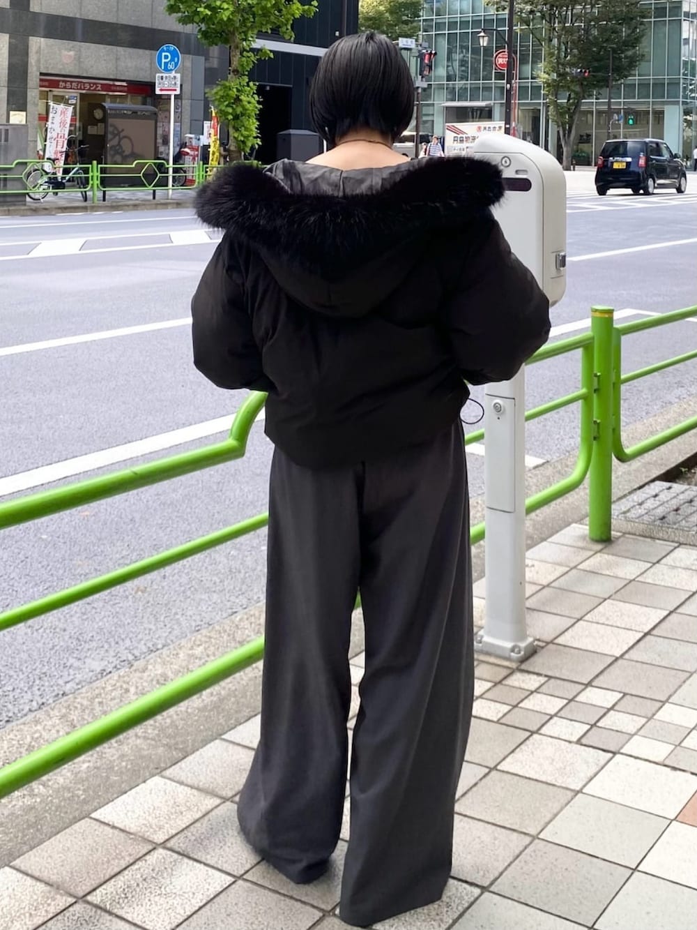 ブラック系のブルゾン、グレー系のスラックスを着用したレディースの秋コーディネートの3枚目の写真