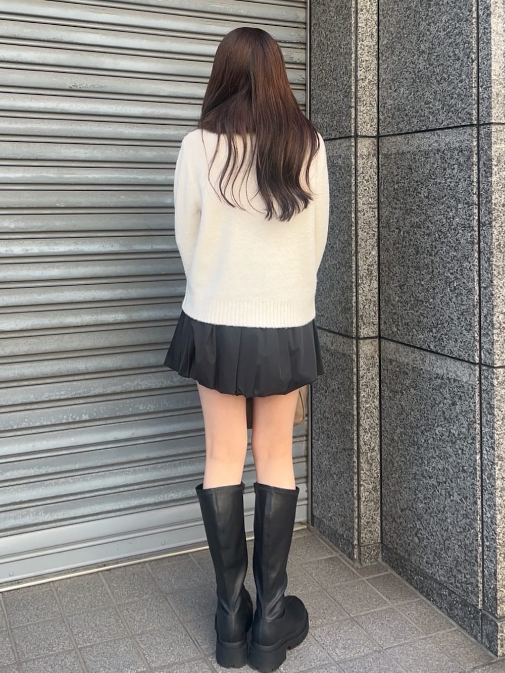ホワイト系のカーディガン/ボレロ、ブラック系のスカート、ブラック系のブーツを着用したレディースの秋コーディネートの3枚目の写真