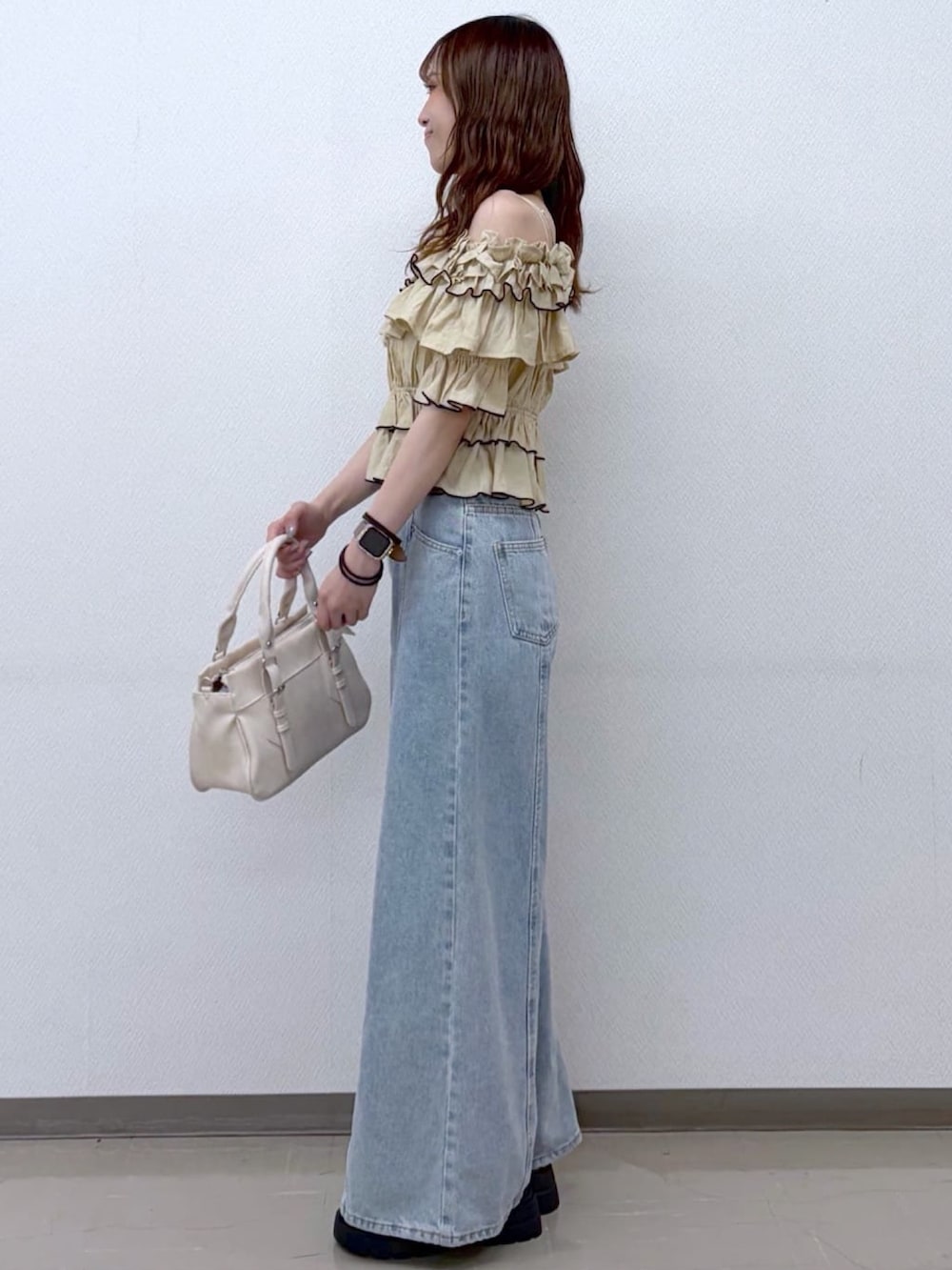 ベージュ系のシャツ/ブラウス、ホワイト系のショルダーバッグ、ブルー系のデニムパンツを着用したレディースの夏コーディネートの2枚目の写真