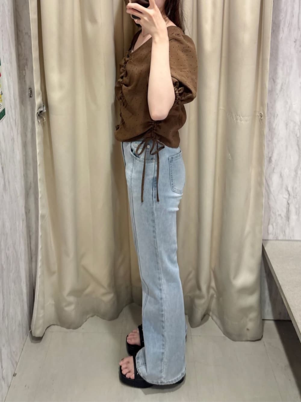 ブルー系のデニムパンツ、イエロー系のサンダル、ブラウン系のシャツ/ブラウスを着用したレディースの夏コーディネートの2枚目の写真