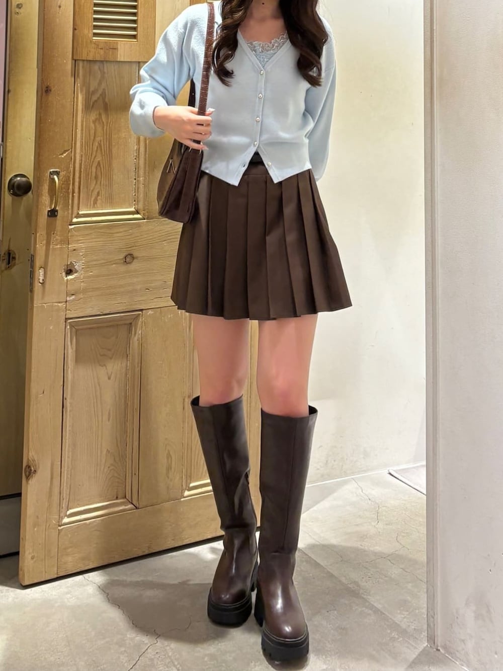 ブルー系のニット/セーター、ブラウン系のスカートを着用したレディースの冬コーディネートの2枚目の写真